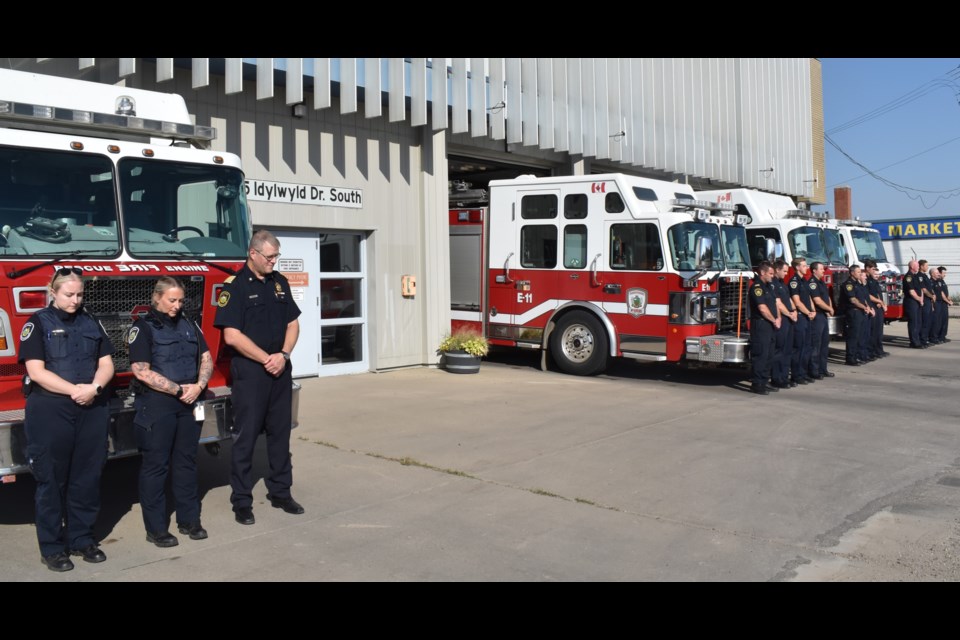 Saskatoon Fire Department Chief Doug Wegren, third left, and the firefighters on duty at Station 1 stand silently to honour their fallen colleagues.