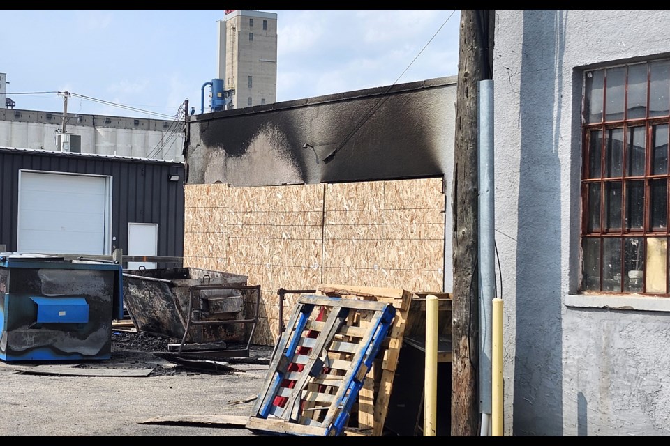 The two garbage bins were severely burnt, and the back door was boarded up after the fire.