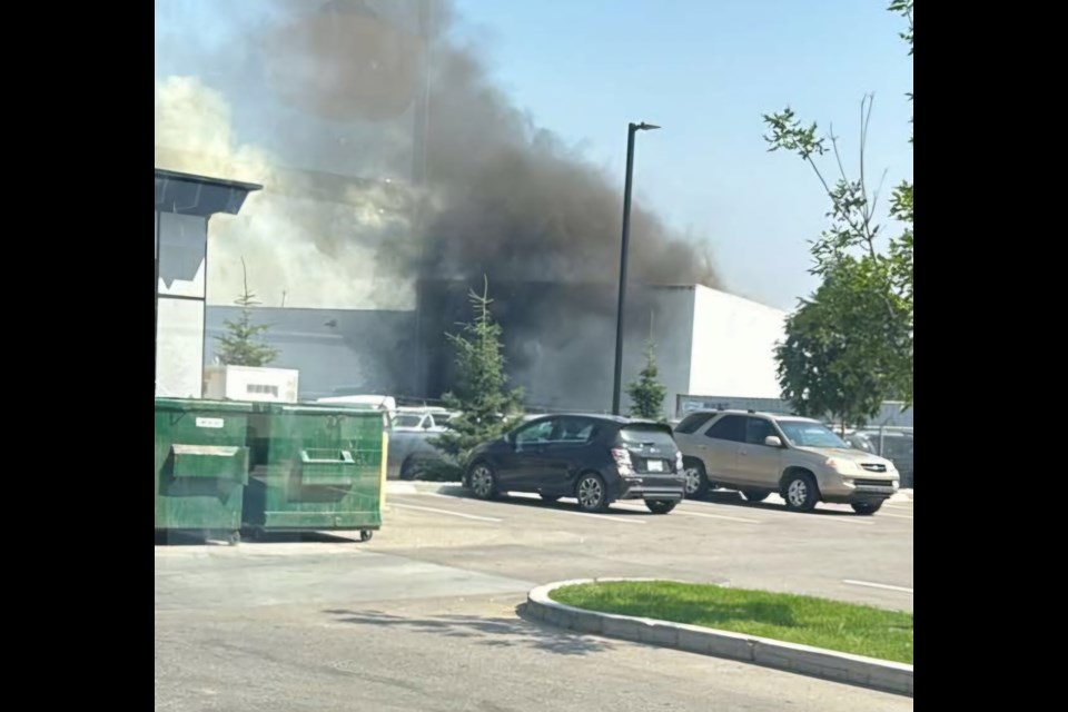 Smoke comes out on the rooftop as Prestige Flooring & Hardwood caught fire on Wednesday, July 24.