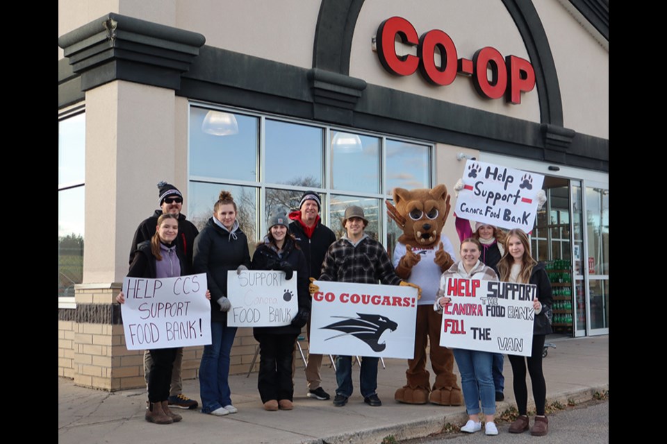 Canora Composite School students and teachers were all over the Gateway Co-op parking lot on Oct. 24, collecting food and taking donations as part of their Fill the Van Food Drive for Filling the Gap Food Bank in Canora. From left, were: (back row) Curtis Baillie and Dustin Nielsen (teachers: (middle) students  Lila Wilson, Jessee Kopelchuk, Makayla Heshka, Ty Sleeva, Cougar mascot (alter ego of Miah Ruf), and Katy Hauber (holding up sign); and (front) Meekah Unick and Jada Nordin.