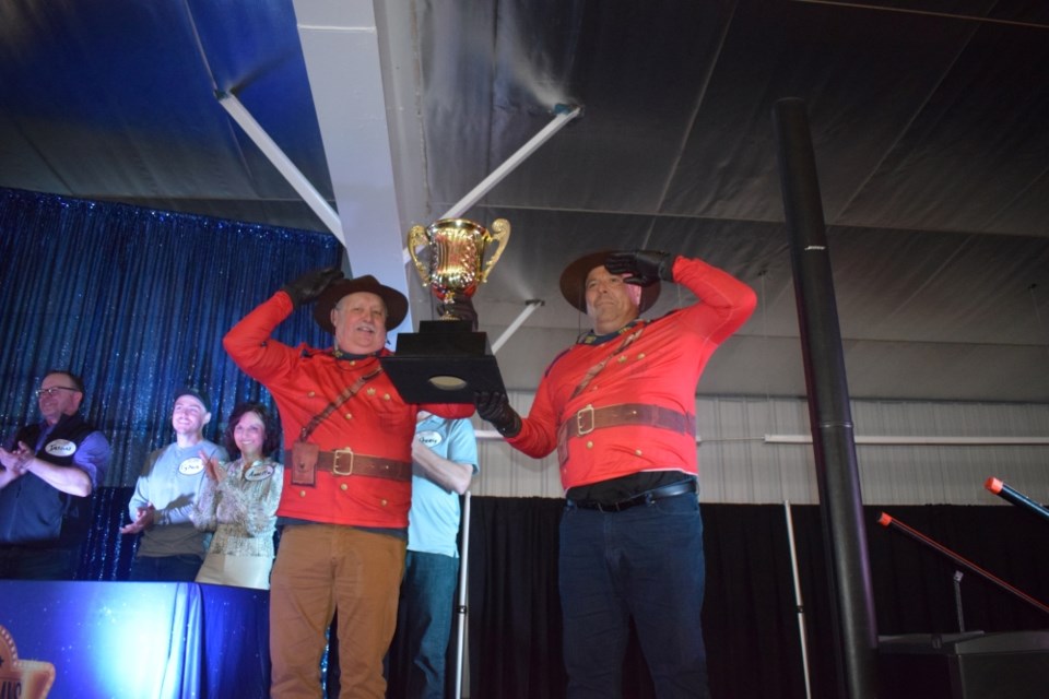 Councillors Lindsay Clark, left, and Tony Sernick donned RCMP uniforms and brought in the Survey Says trophy.