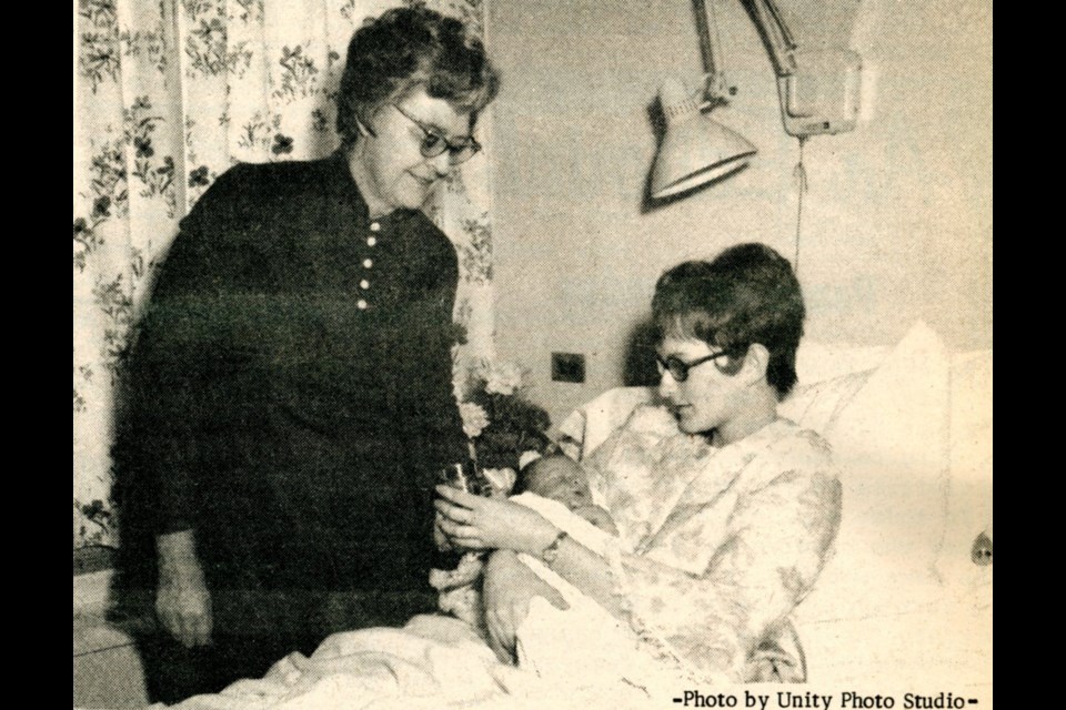 Mrs. Ralph Simmons, president of the Unity Union Hospital Auxiliary, presents a silver cup to Bradley James Ireland and his mother, Mrs. Ron Ireland. Bradley was the first baby of 1973 born at Unity Union Hospital.