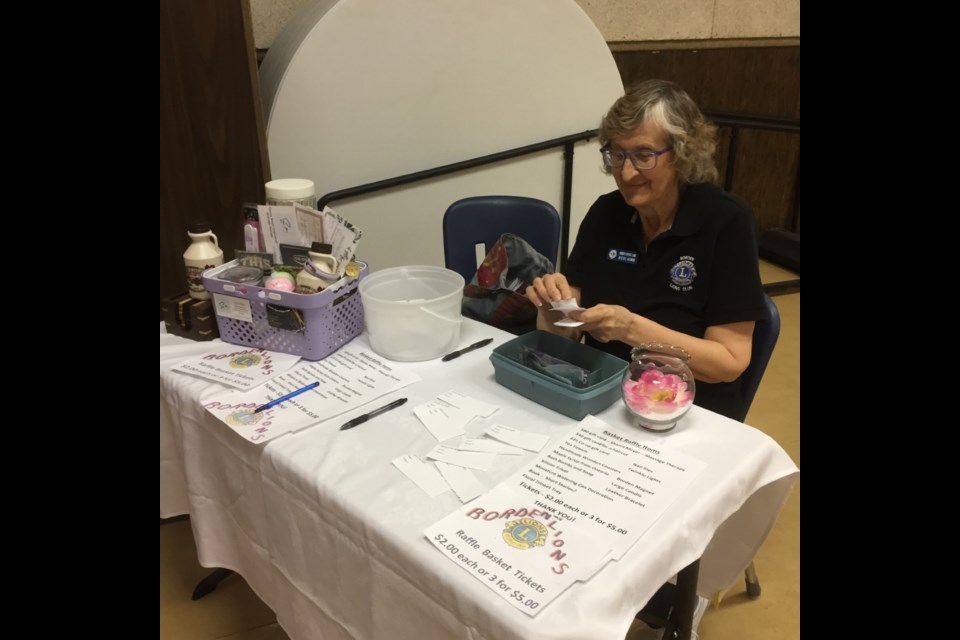 Bev Assman selling Mother's Day raffle tickets on a basket of goodies at a brunch hosted by the Borden Lions May 12.