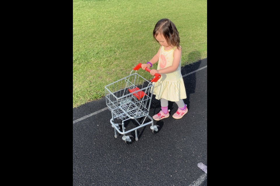 Esther Harris with her cart. Toddlers (ages nine months to three years) with toddler-sized grocery carts will be racing. Any parent/caregiver of a toddler is welcome to join the races with free entry. 