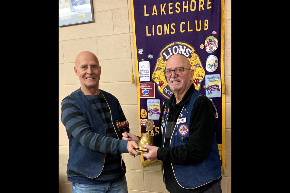 New Meota Lakeshore Lions president Lloyd Ward is handed the president's bell by past president Lawrie Ward. 