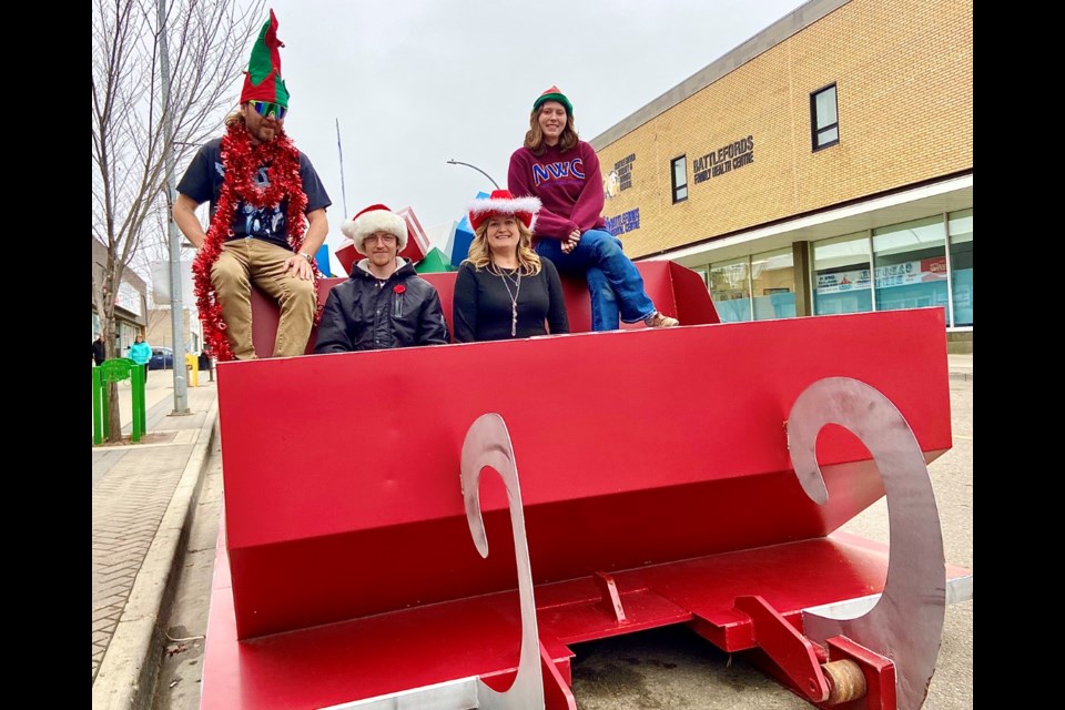 Kurtis Kopp, warehouse; Blake Feist, food bank manager; Erin Katerynych, executive director; and Kristen Murtagh, front-end worker in the Empty Stocking Fund sleigh.