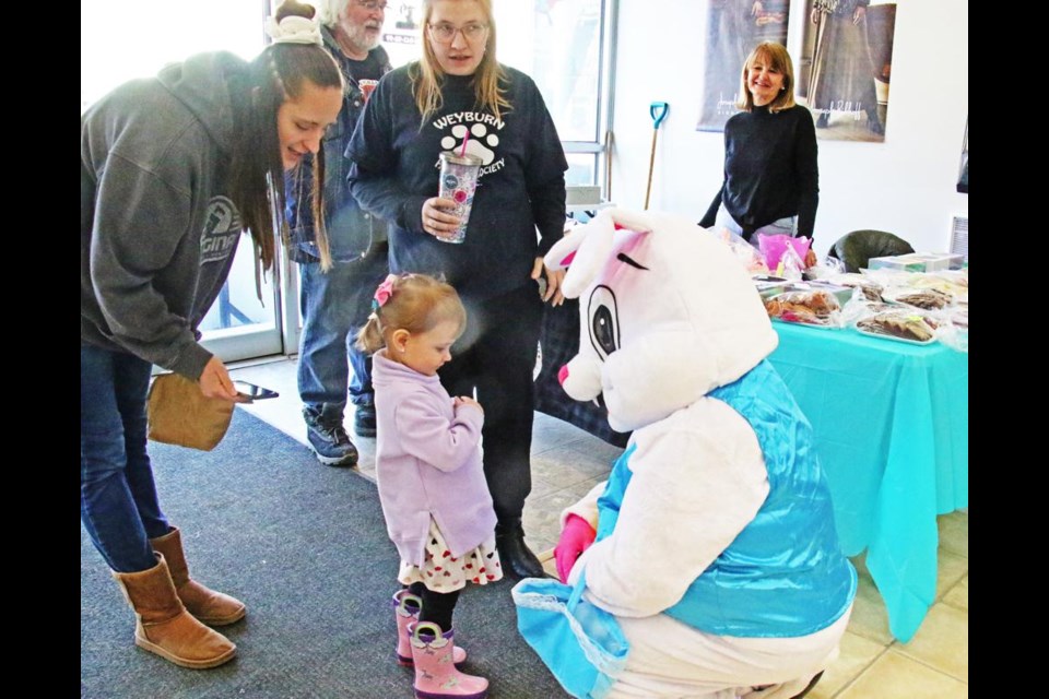 The Easter bunny had a chat with a young fan, Lily Herlick, with the encouragement of her mom, Jennifer Yellowega, left, at the Weyburn Humane Society's fundraiser on Saturday.