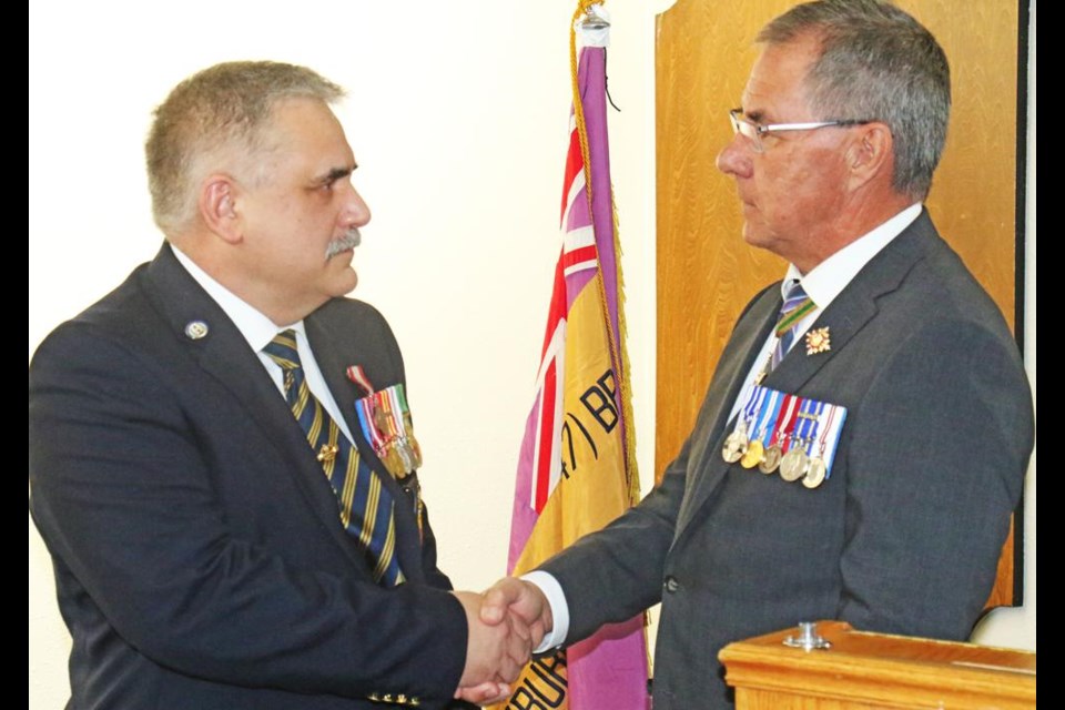 Lt.-Gov. Russ Mirasty shook hands with Harold Whiteoak, congratulating him after presenting the Sovereign's Medal for Volunteers to him at a special luncheon at the Weyburn Legion on Tuesday.