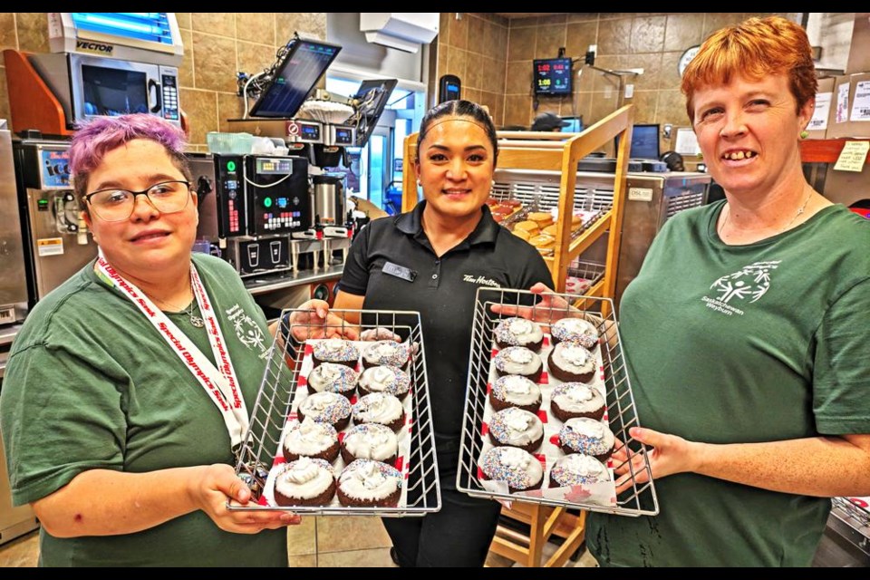 Special Olympics athletes Robin Stelter, left, and Leah Whitrow show off two trays of specially-made doughnuts in support of the Special Olympics in Weyburn, along with Tim Horton’s store manager Marj Carcallas, on Saturday. The special sale of Special O doughnuts ran from Friday to Sunday, with all of the proceeds going to the Special Olympics programs in Weyburn.