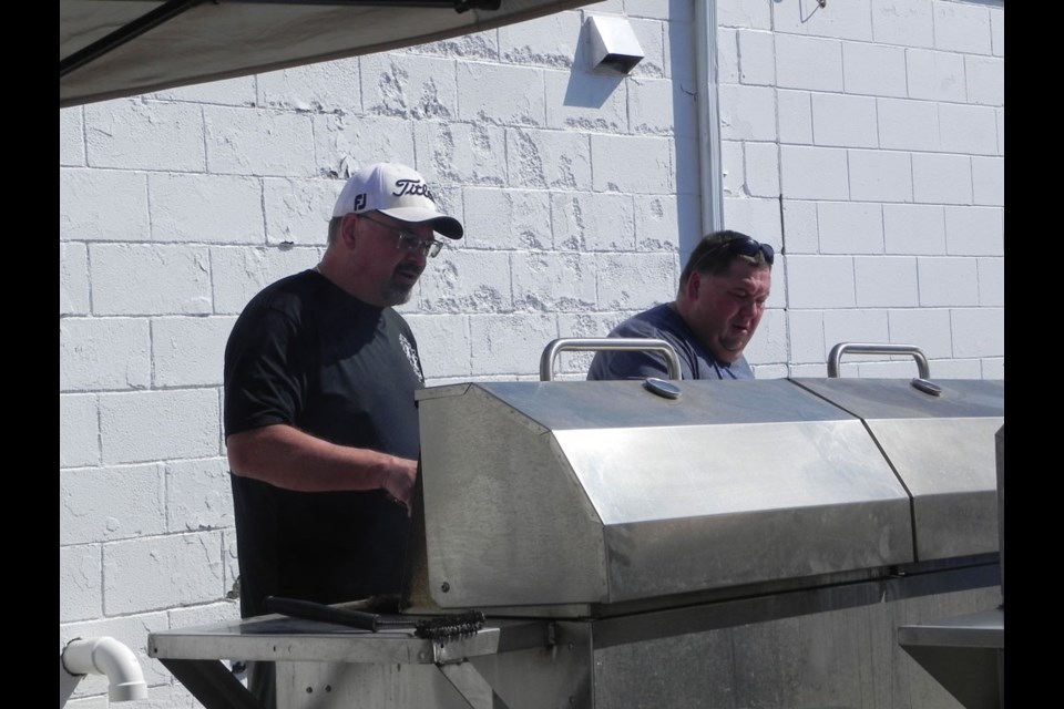 Unity Kin Club members, Mark Krpan and Kurt Elder, were kept busy on the barbecue at a fundraising event for upcoming upgrades at Unity's Kin Park.