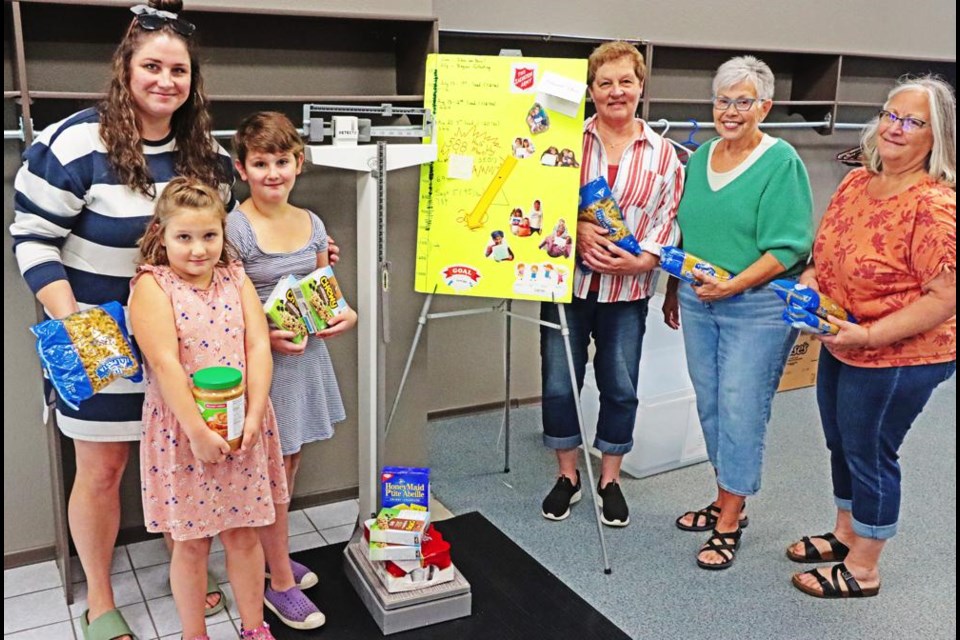 Families of the Weyburn Free Methodist Church gathered with their final donation of food, as they aimed to gather and donate 1,177 pounds of food, the equivalent weight of the kids in the church. At left are Megan Schick and her daughters Emily and Madisyn, and to the right of the weigh scale are Marnelle Cornish, Gwen Wright and Evelyn Sollosy.