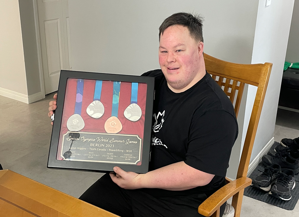 aaron-higgins-sits-with-his-medals