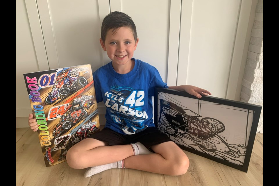 Eli Turnbull with a colouring prototype of his race car in Captain Insano book. 