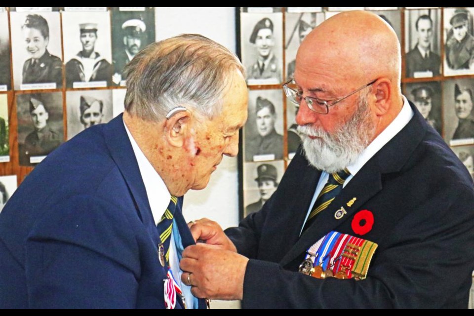 Weyburn veteran Howard Schmidt, left, had the French Legion of Honour medal pinned on by Ken Turner, a Legion member from Estevan, at a presentation on Saturday at the Weyburn Legion Hall with Howard's extended family present.