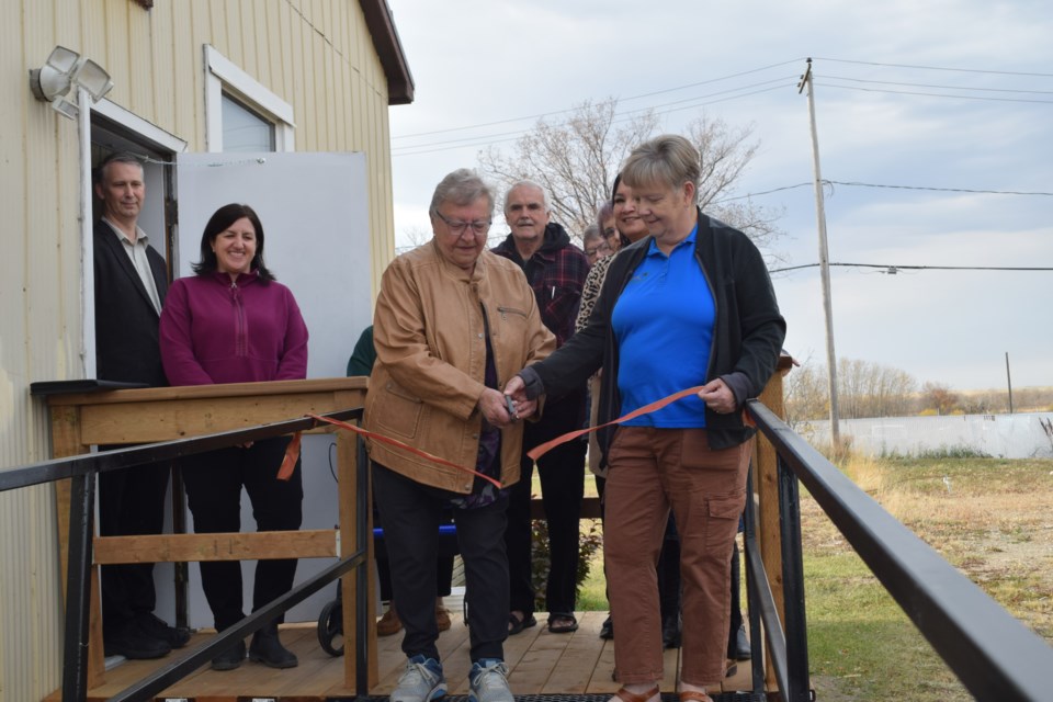 Cutting the ribbon for the Grand re-opening were, left holding scissors, Betty Dix, and Mayor Nancy Brunt.