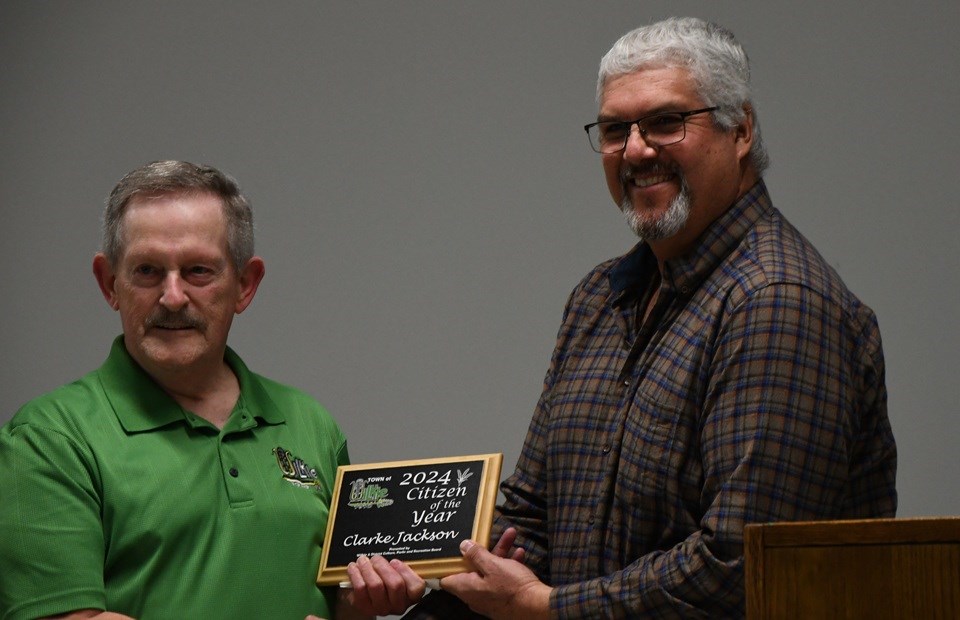 Clarke Jackson, left, accepts his Citizen of the Year plaque from Wilkie town councillor Les Henderson. 