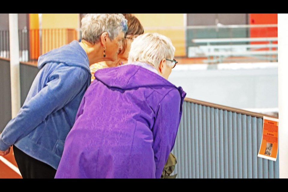 Participants in Weyburn's Walk for Reconciliation stopped to read one of the signs posted on the railing of the indoor walking track on Monday. These posters were originally posted along the path in Jubilee Park, but the signs were vandalized twice, once on Sunday and prior to that on Sept. 24. The city police is investigating this vandalism.