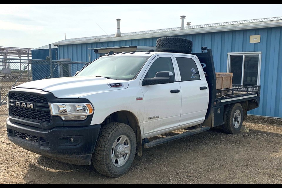 The flatbed truck is unique and has metal head rack with “Steel Reef” logos on the rack and has a spare tire mounted on top of the cab.