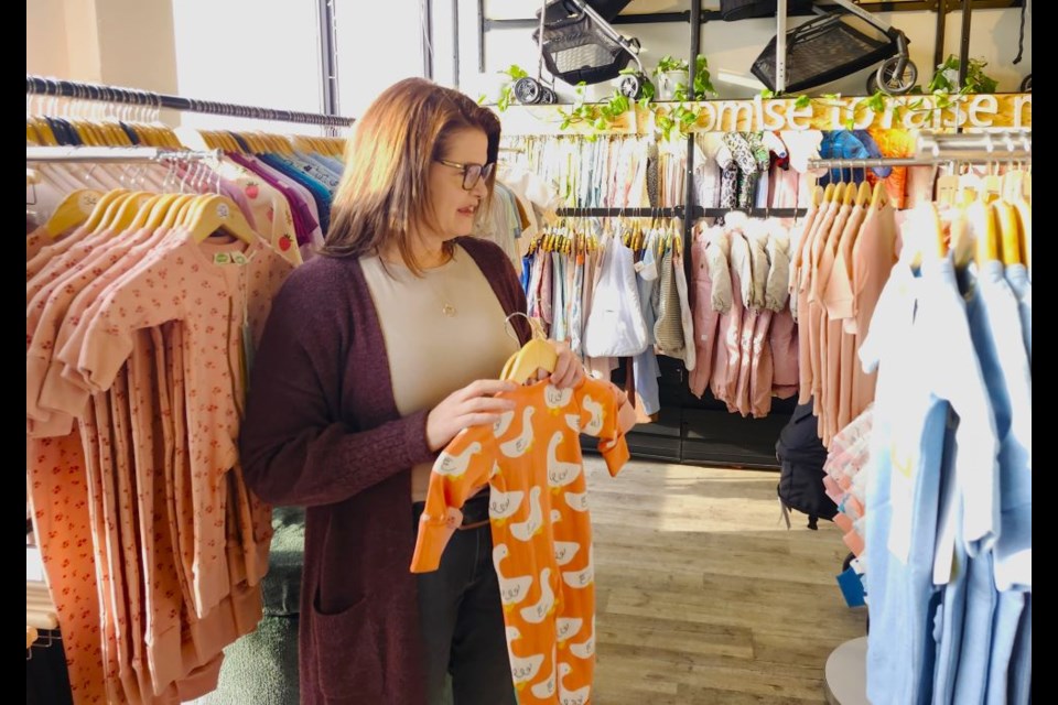 Saskatchewan NDP Leader Carla Beck looks around for baby clothing she plans to give as Christmas gifts.