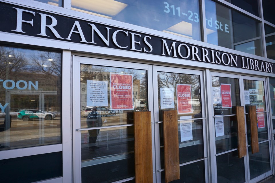 A library patron's reflection can be seen as she reads the closure sign at the Frances Morrison Public Library downtown.