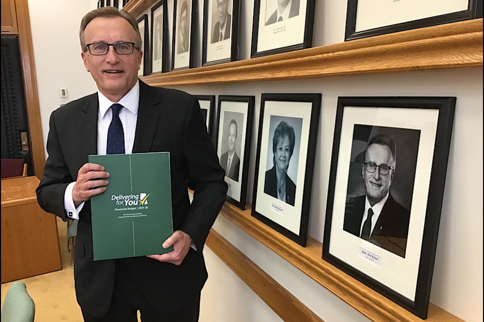 Finance Minister Jim Reiter stands with the fresh off the presses 2025-26 provincial budget document.