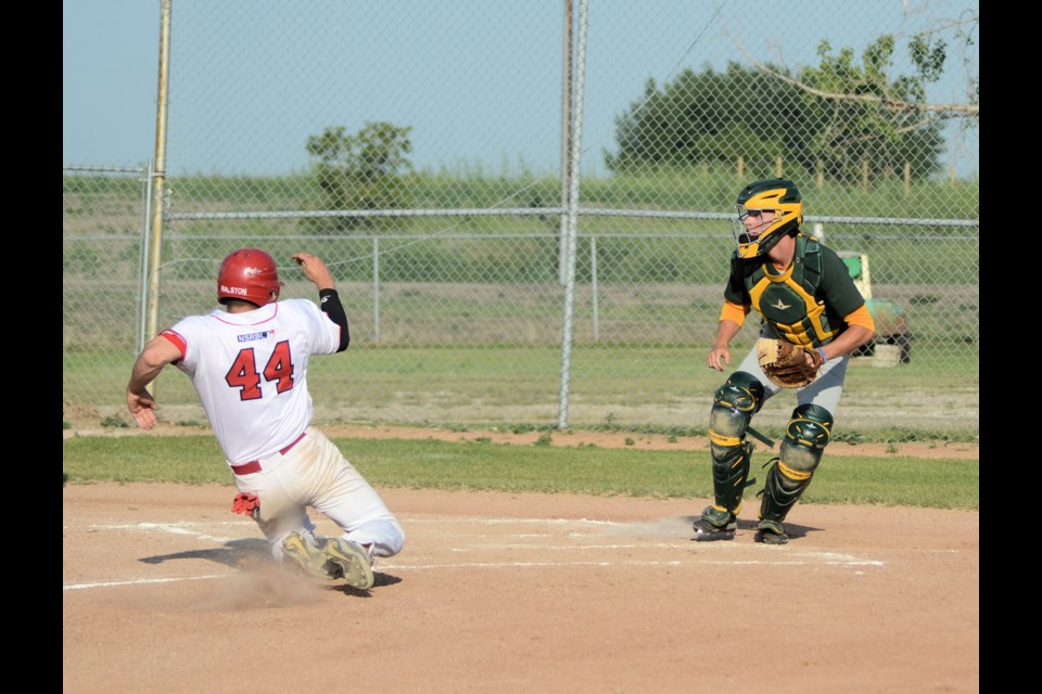 Unity Caridinals player, Thomas Feser, slides into home to score the first run of the June 29 game on an RBI hit from fellow player, Brayden Schultz.