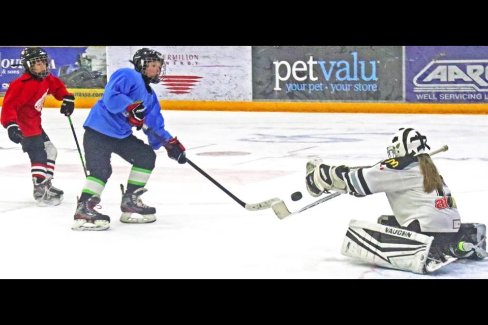 The goalie for Team Red had her catcher's mitt out for this shot by a Team Blue forward, during a U11 game on Saturday.