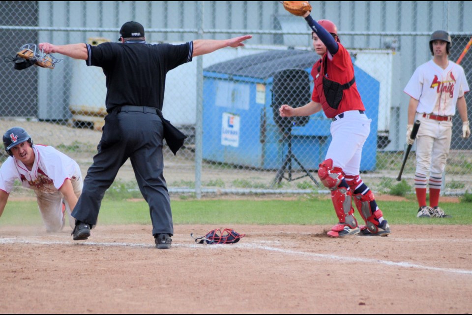 Cards Cory Wildeman checks to see umpire Mike Tardiff's call after sliding into home plate during the Cardinals' playoff action against Lloydminster Twins July 11.