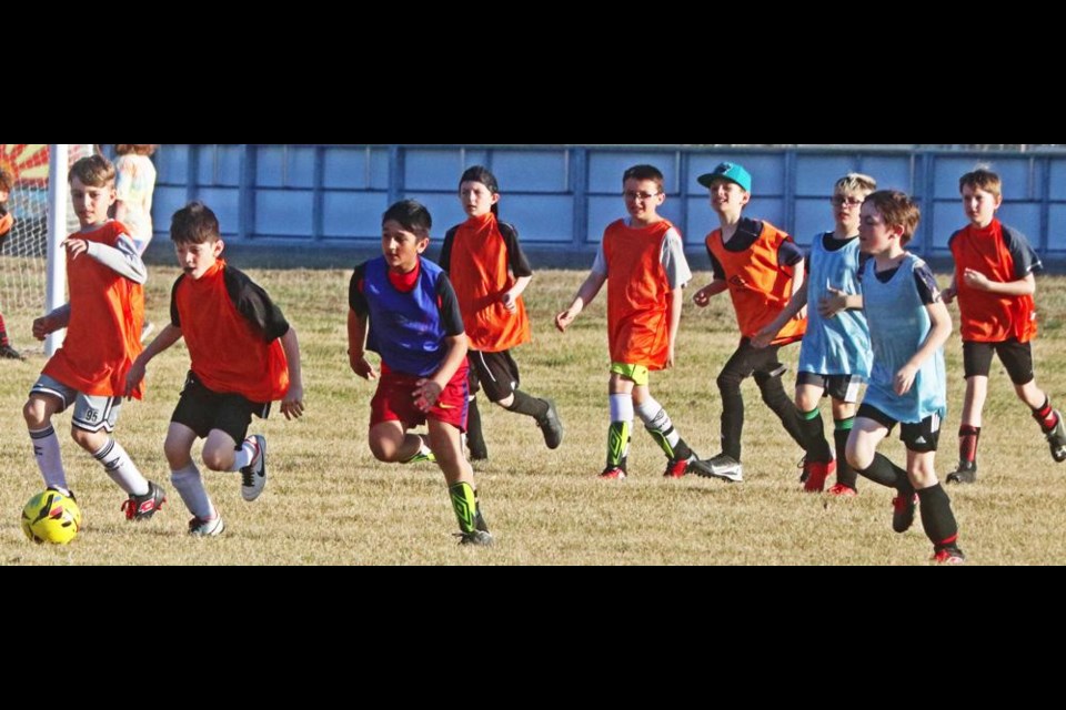 Boys chase the ball down the field during a practice at Jubilee Park on Thursday evening.