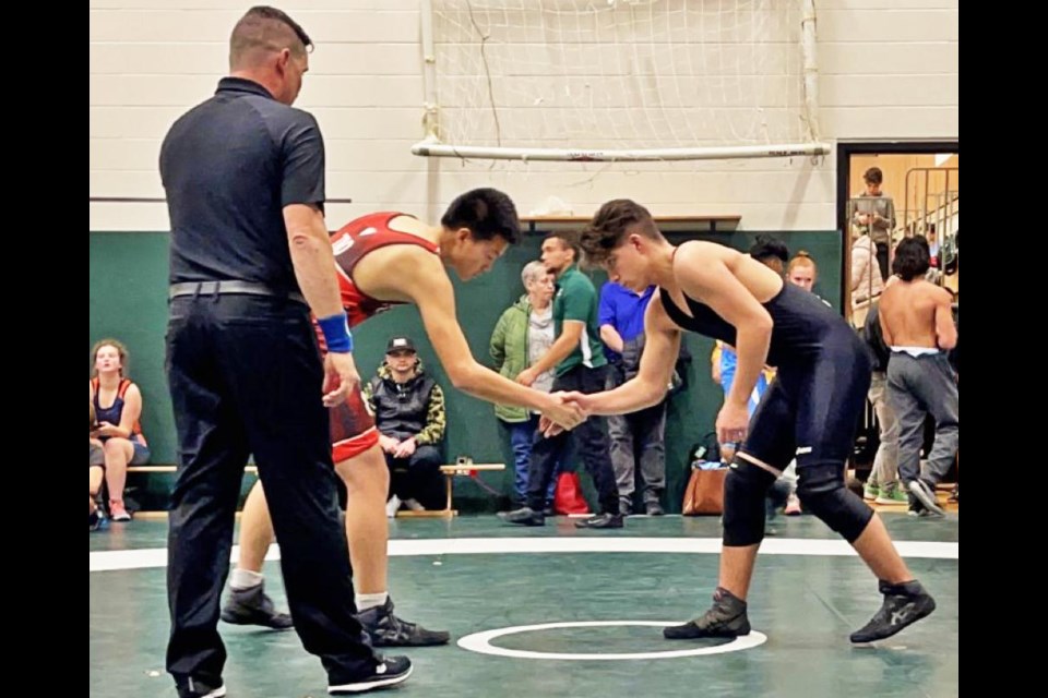 Cale Mohan of Weyburn, at right, shook hands with his opponent at the Kelly Dumont Memorial Tournament on Saturday, where he won first place in his weight division.