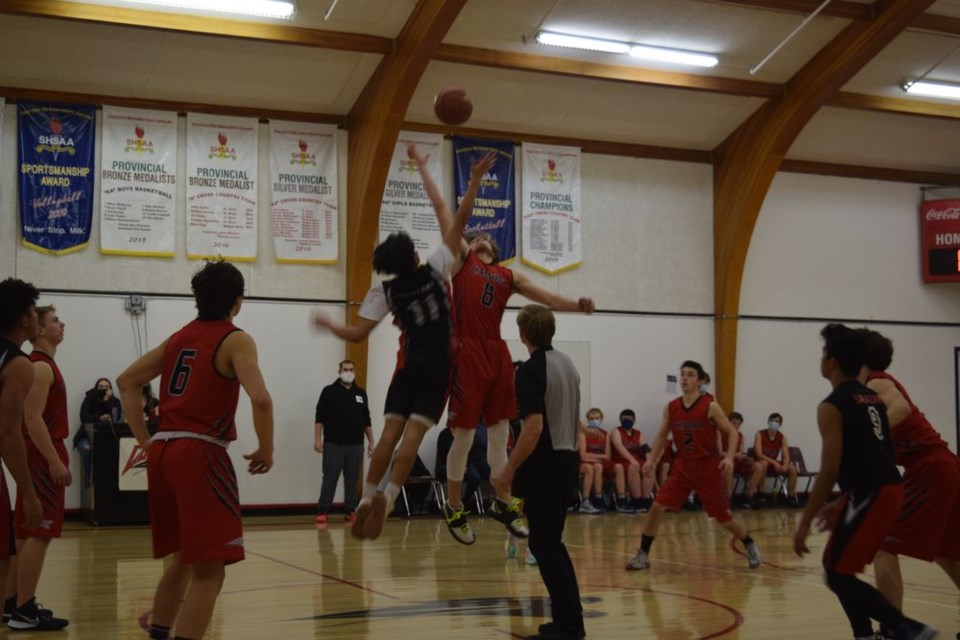 Brendon Landstad, No. 8 of the Canora Composite School Cougars senior boys basketball team (red jerseys) won the tip to open the game against the visiting Foam Lake Panthers on February 7. Other starters for the Cougars, from left, were: Joey Palagian, Toby Olynyk, Dawson Zuravloff and Hudson Bailey. / Rocky Neufeld