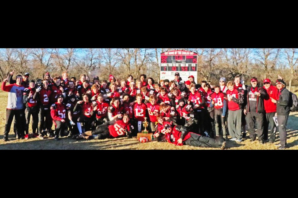 The players and coaching staff of the Weyburn Comp Eagles football team gathered with the trophy for the SHSAA 5A Provincial Championships under the scoreboard, showing how they defeated the Saskatoon Aden Bowman Bears 35-15 at Darold Kot Field on Saturday afternoon.