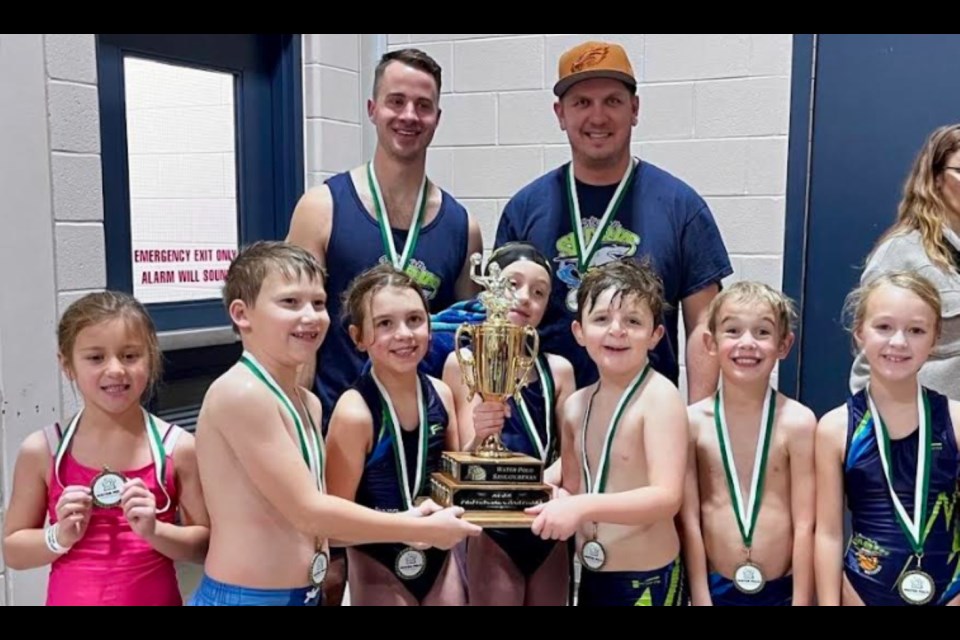 The U9 Sharks with their winter provincials trophy: Sophie Kawecki, Tripp Davies, Lexi Olson, Rose Chabot, Sawyer Klotz, Nicolai Mitchell and Hayden Friess. Coaches are Paul Chabot, Matthew Olson.