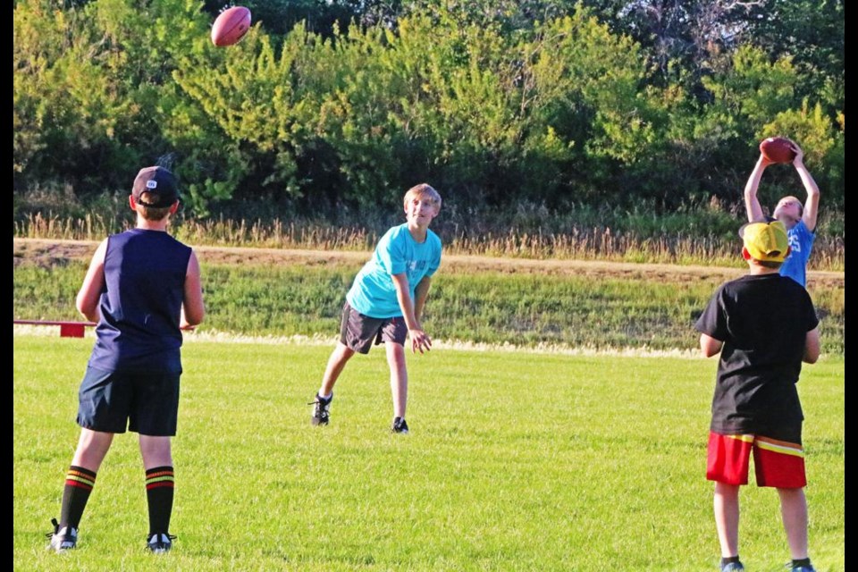 Athletes attending a mini-camp practised passing and running at WMF Field on Wednesday evening. Minor Football's new season will start on Monday, Aug. 19 with practices.