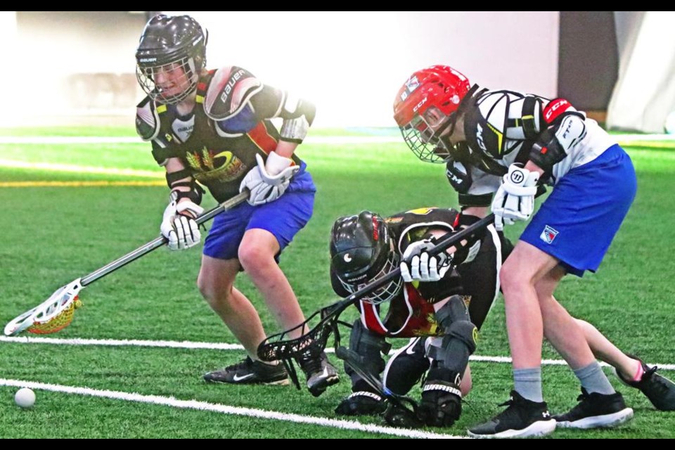 A trio of players goes after the ball in this drill for the U15/U17 field lacrosse players, at their first practice of the season on Friday evening, at the CU Spark Centre.