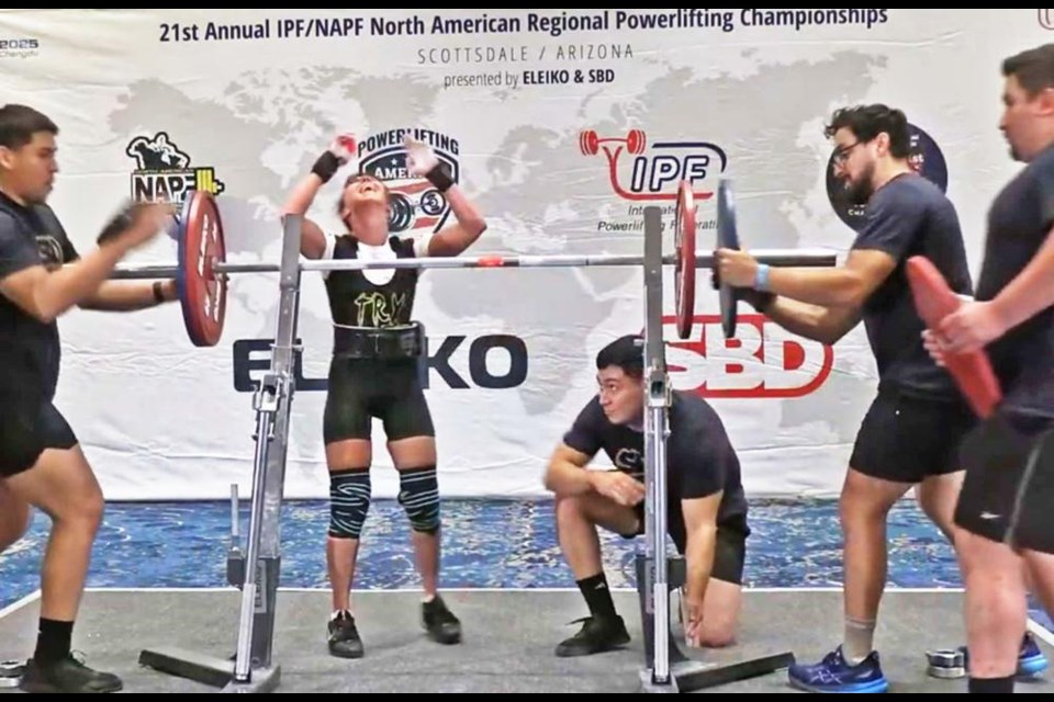 Power lifter Marnel Spencer, centre, reacts after she set a world record lift of 120.5 kg, or 266 pounds, in the 45-kg body weight category.