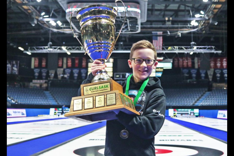 Nathan Cornish, a youth curler from Weyburn, hoisted the trophy for winning first place in the 9-10 age category in the Hit-Draw-Tap competition, put on by CurlSask.