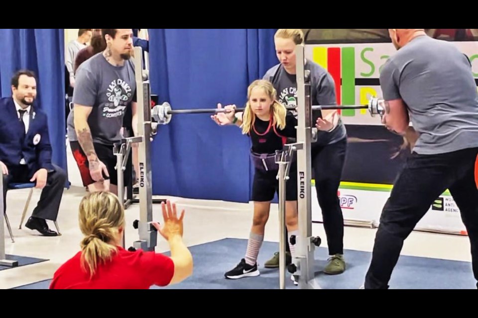 Paige watched her mom, Chelsea, for her squat commands. Lifters must pause after they complete their lift until the referee yells to “rack” the bar. 