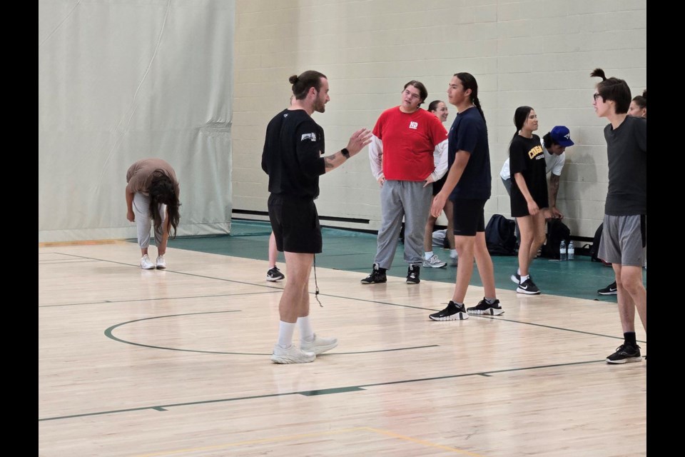 Blake Moulding (left) head of Strength and Conditioning for men and women's track and field and cross country teams at the U of R, speaks with students Eagle Dubois (blue T-shirt) listens attentively during a strength and conditioning exercise in the gymnasium on the Regina campus. *