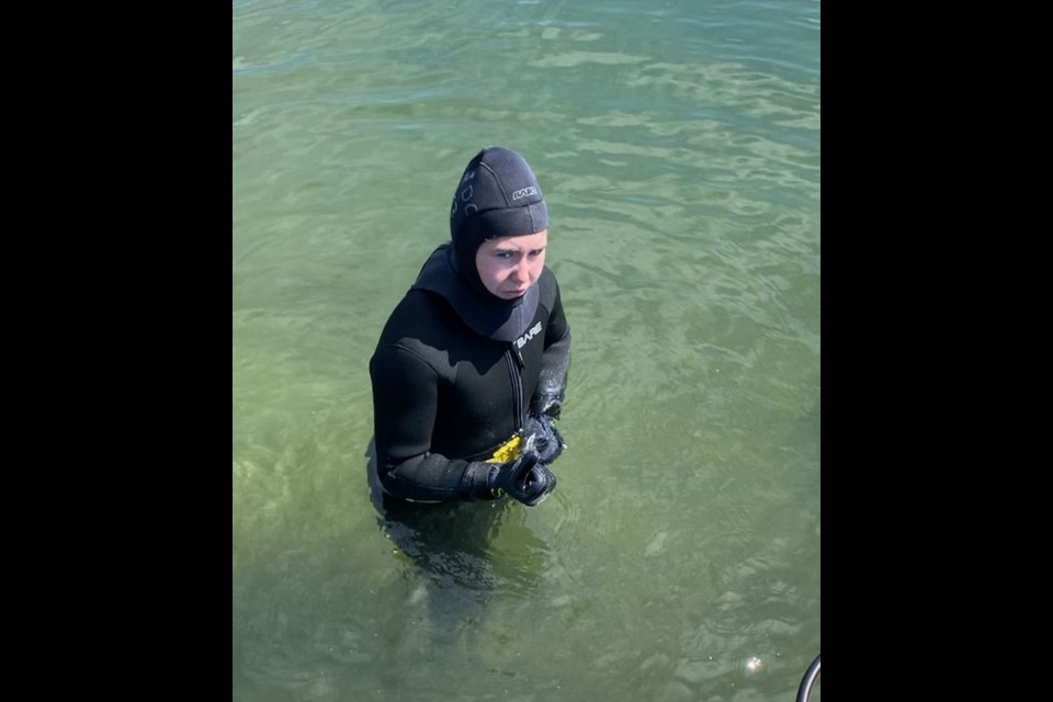 Caybre Stynsky doffing her gear after her first dive. 