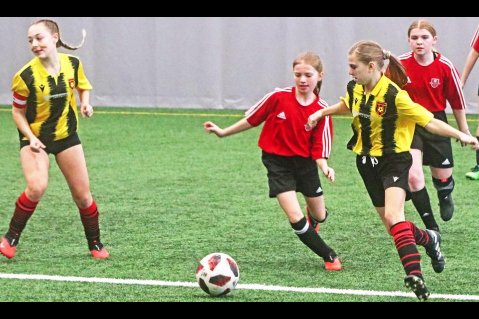 Two players on the U13 girls teams from Moose Jaw (red) and Weyburn (yellow) tried to get possession of the ball during tourney play on Saturday.