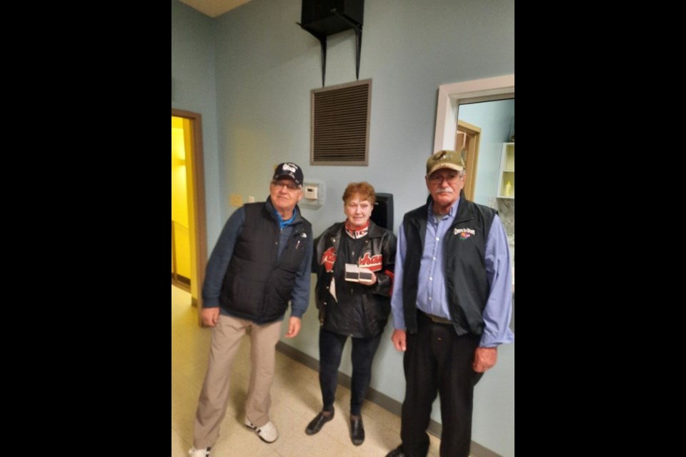 On behalf of her late husband Ted, Del Palagian presented infinity lighters to the winning team of the Ted Palagian Memorial Two-Person Stick Bonspiel held on Family Day, February 21. The winners were Robert Waselenko, left, and Bill Foreman.

