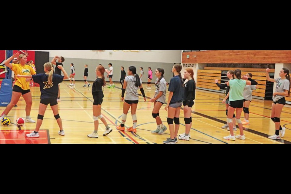 Participants in the junior high camp lined up for a drill, and were shown the technique for spiking the ball down hard prior to giving it a try.