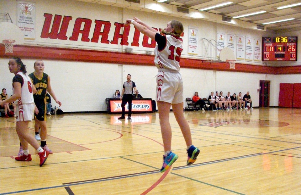 Maycie Gumpinger takes a shot from the three point line, gaining a bit of air at the same time, as Chloe Parungo watches for the rebound.