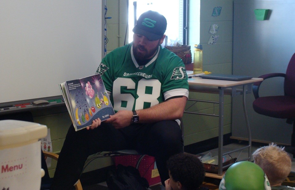 Offensive lineman Noah Zerr, who stands at 6' 7", towered over the Kindergarten class at St. Peter's School, March 19.                            