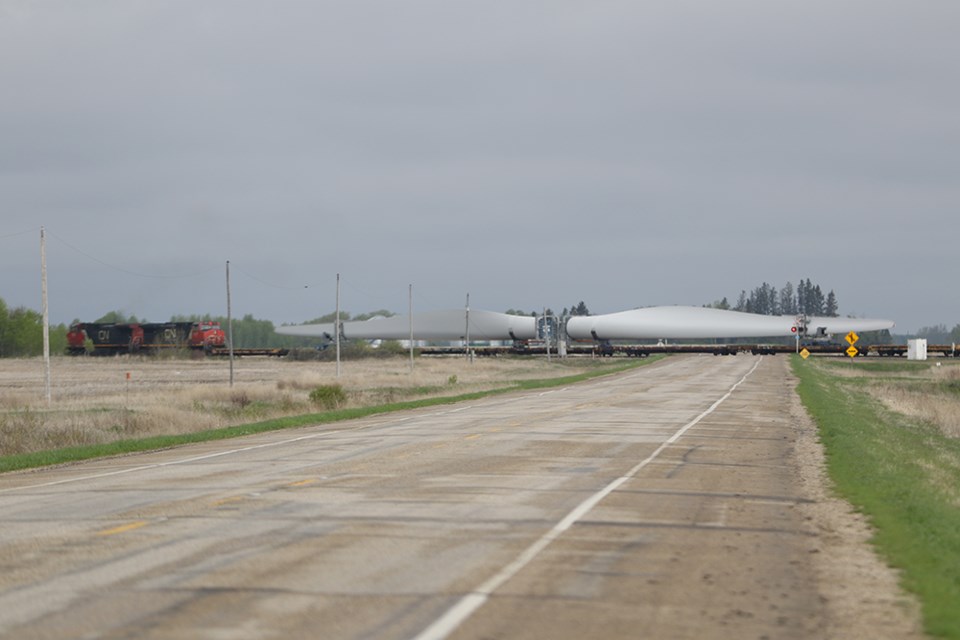 A train transporting a convoy of large windmill blades passed through Canora on the morning of May 21. Here it crosses Highway 5 west of town.