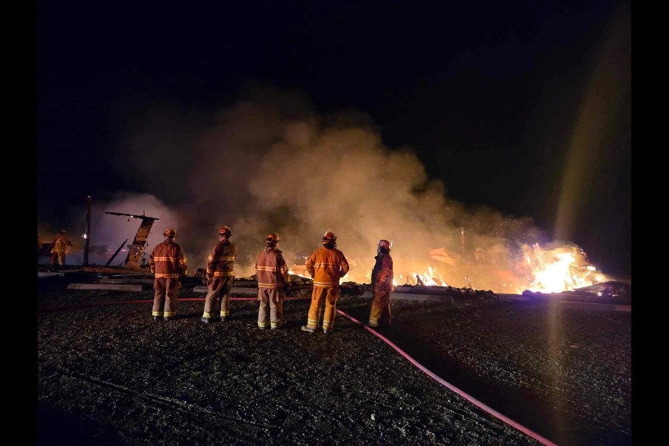 Firefighters from Manitou Lake Fire and Rescue and Neilburg Fire Department watch the dining hall burn to the ground, unable to save the building.