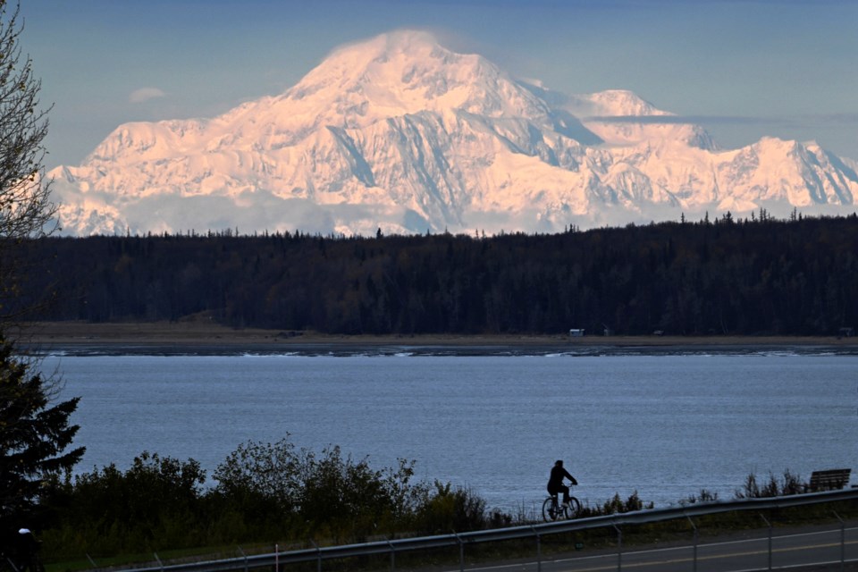 Denali is visible from Pt. Woronzof, Oct. 9, 2024, as a person rides a bicycle on the Tony Knowles Coastal Trail. (Bill Roth/Anchorage Daily News via AP)