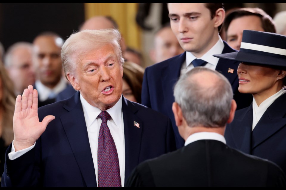 President-elect Donald Trump, from left, takes the oath of office as son Barron Trump and wife Melania Trump watch during the 60th Presidential Inauguration in the Rotunda of the U.S. Capitol in Washington, Monday, Jan. 20, 2025. (Kevin Lamarque/Pool Photo via AP)