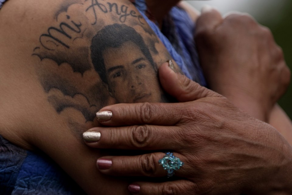 Doris Tejada touches the tattoo of her missing son Oscar Morales as she gives an interview in Bogota, Colombia, Tuesday, Nov. 5, 2024. Tejada said her son disappeared in 2007 near the Venezuelan border and became a "false positive," a civilian intentionally registered as a rebel and slain by the military. (AP Photo/Ivan Valencia)